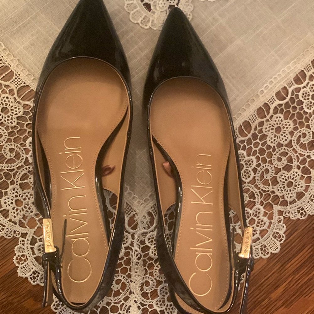 Woman’s patent leather sling back heels.